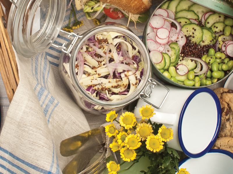 Containers of salad and flowers in a picnic basket
