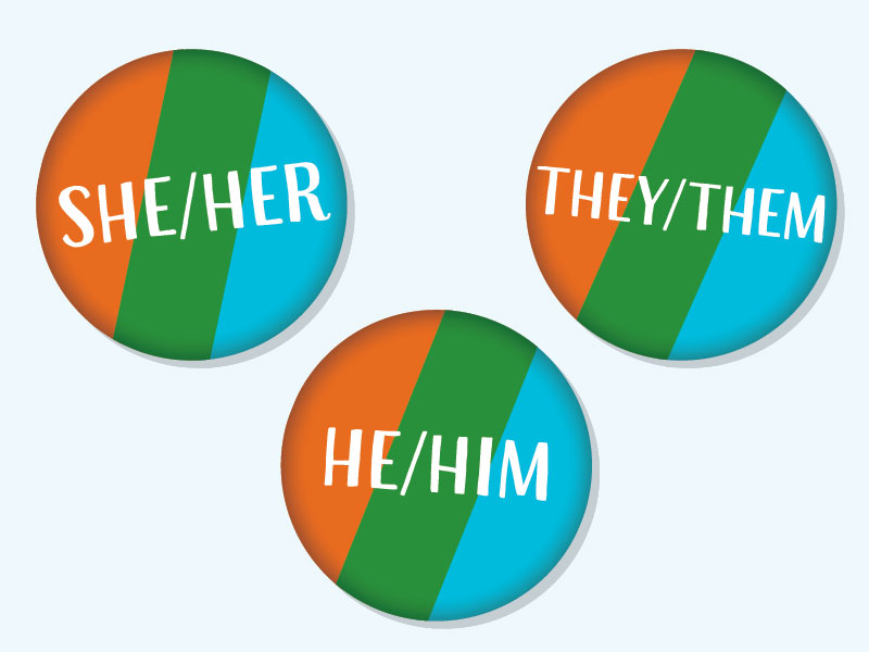 3 orange, green and blue stripped buttons with gender pronouns on them. "She/Her" "He/Him" "They/Them"